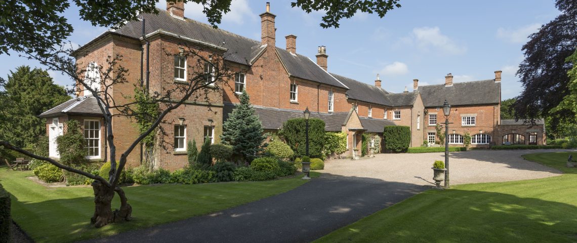 Bradley Hall, a red brick period country house with a sweeping driveway and gardens