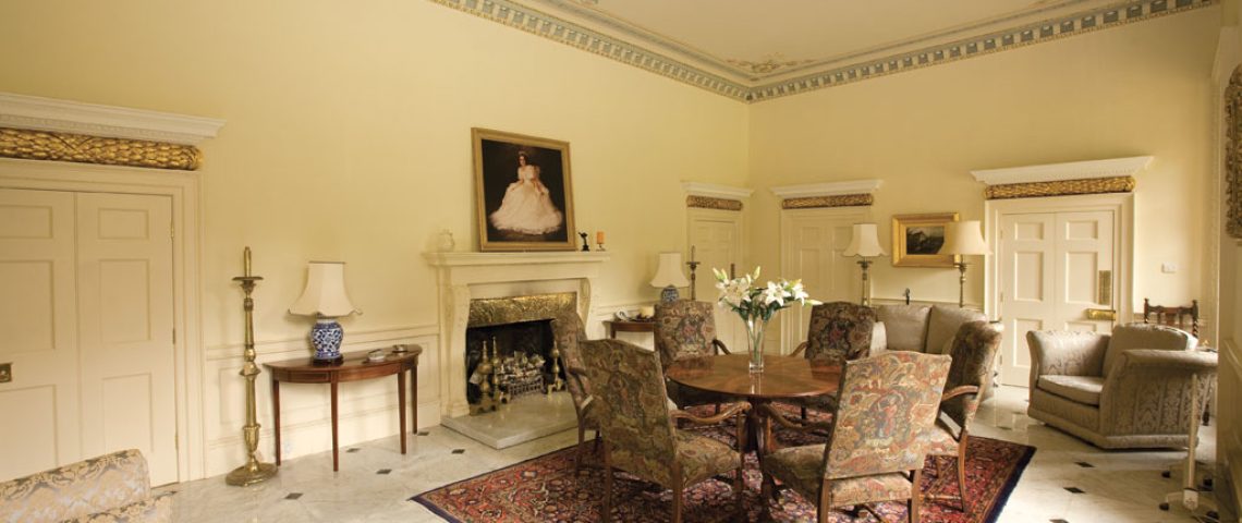 Traditional dining room at Stoke Hall with a marble fireplace and antique furniture