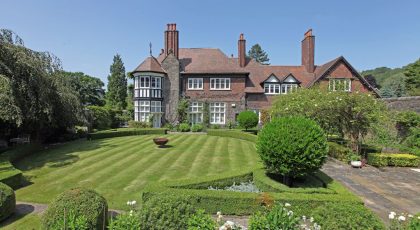 Period country house with a manicured lawn and topiary, linking to the Homes for Sale page